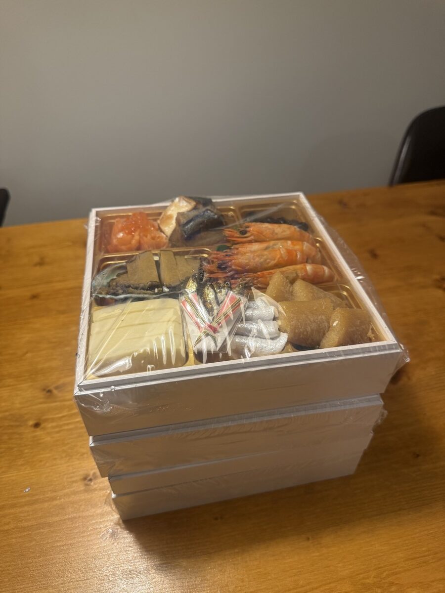 冷凍便で届いた大地を守る会のおせち宝泉華をラップのまま三段重ねた状態。冷凍庫に入れる前の大きさがわかる