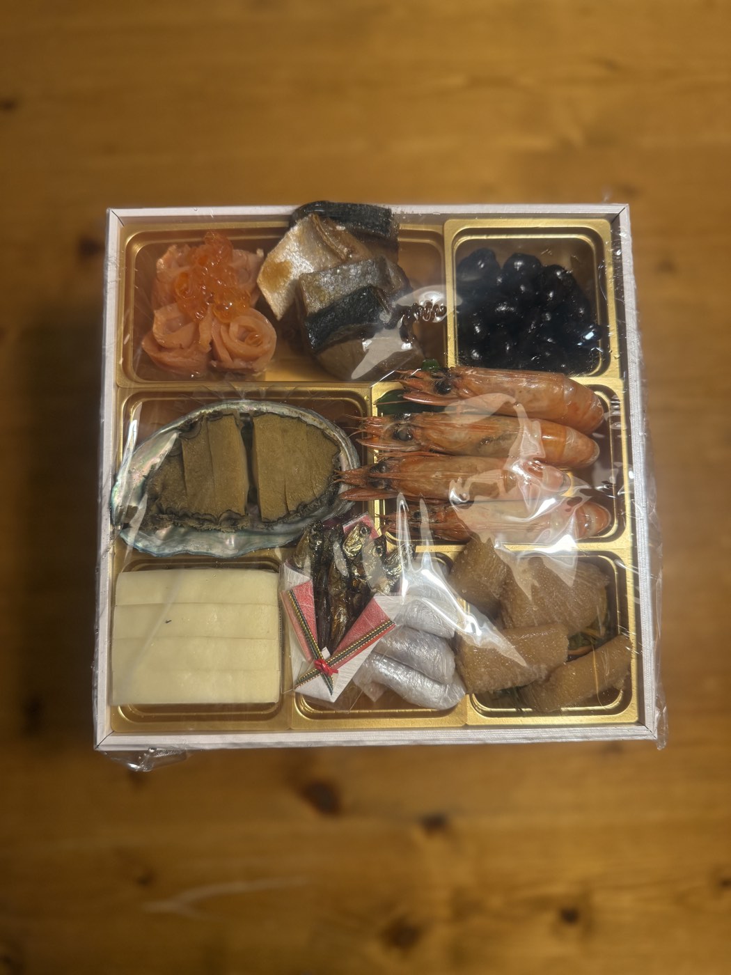 冷凍便で届いた大地を守る会のおせち宝泉華の壱の重をラップのまま真上から見たところ